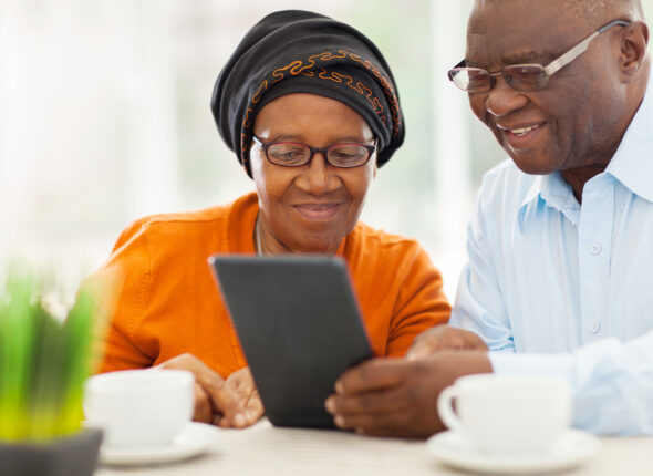 Lovely,Elderly,African,Couple,Using,Tablet,Computer,At,Home