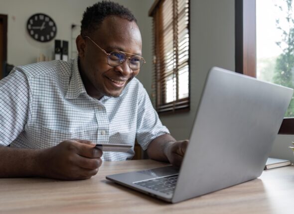 Black,Man,Holding,Credit,Card,For,Online,Shopping,And,Payment